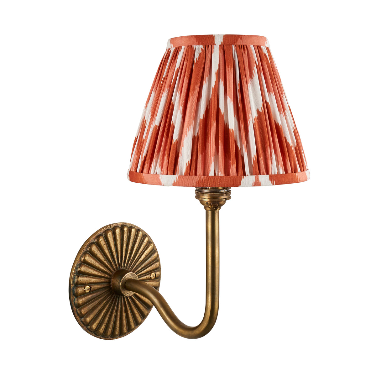 Dahlia Swan antique brass wall light with orange ikat pleated shade, studio shot on white