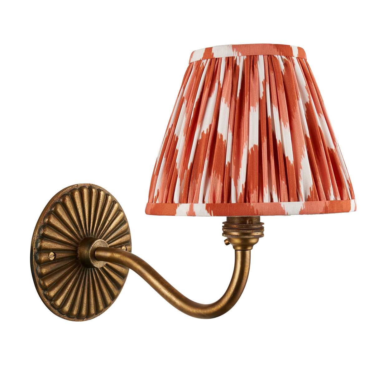Dahlia Curve brass wall light with orange ikat shade, shown from a slightly higher angle