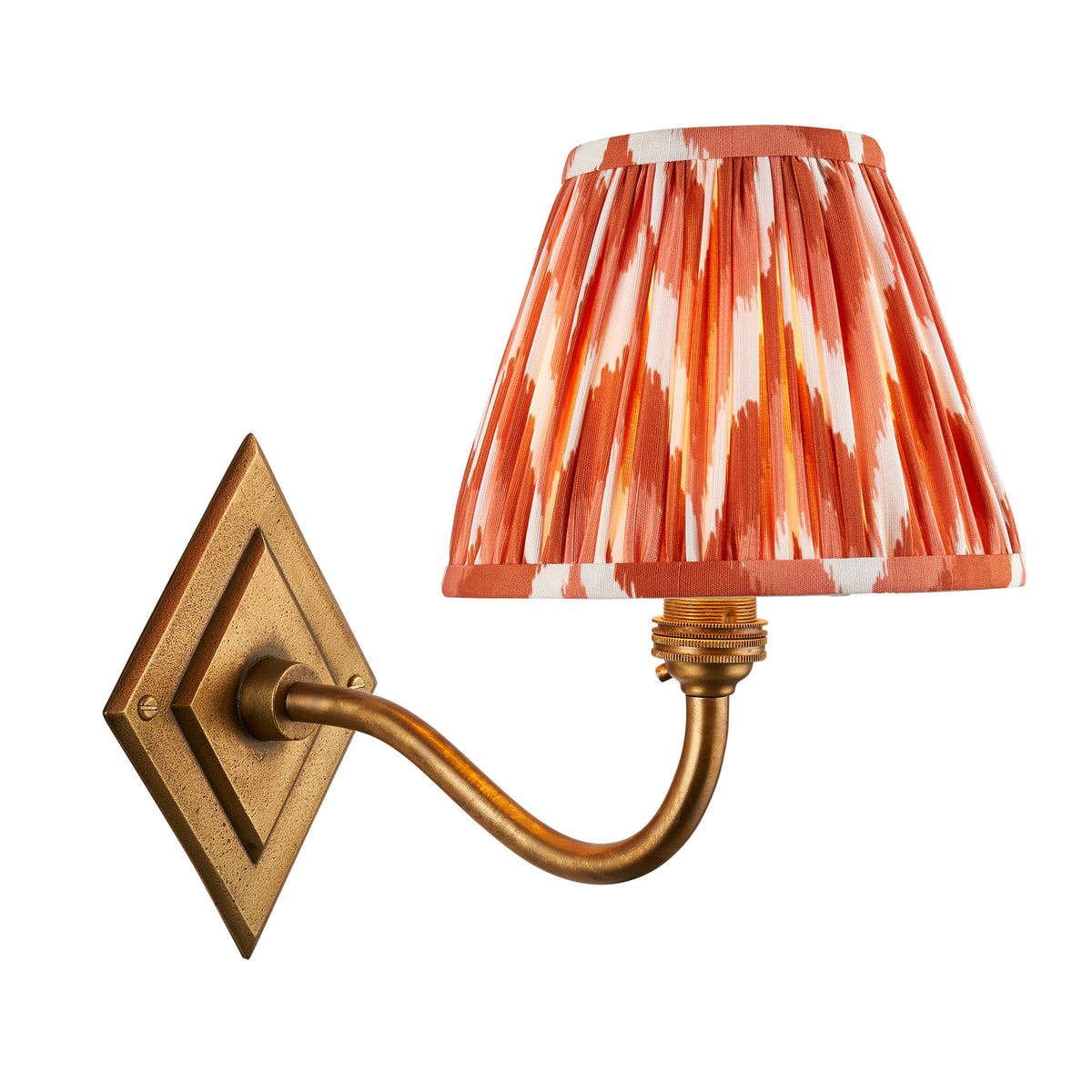 Diamond Curve antique brass wall light with a pleated orange zigzag ikat shade on a diamond backplate