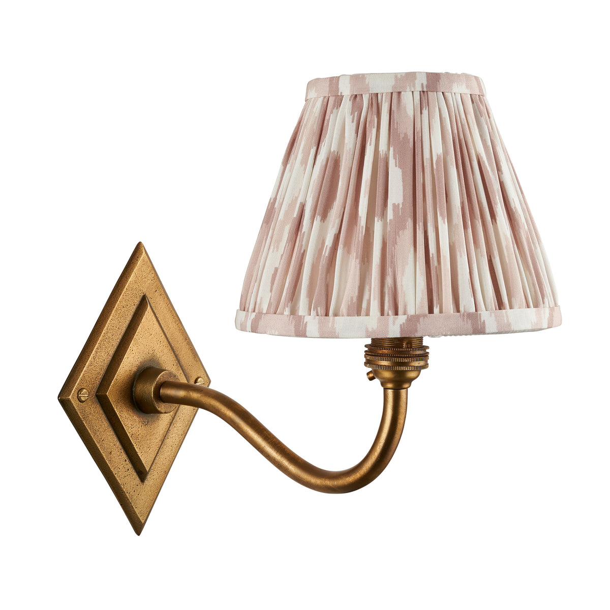 Diamond Curve antique brass wall light with dusky pink ikat pleated shade on a white background