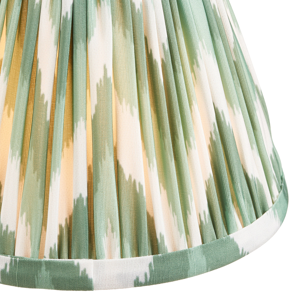 Close-up of sage green and cream pleated ikat fabric with a bound bottom trim