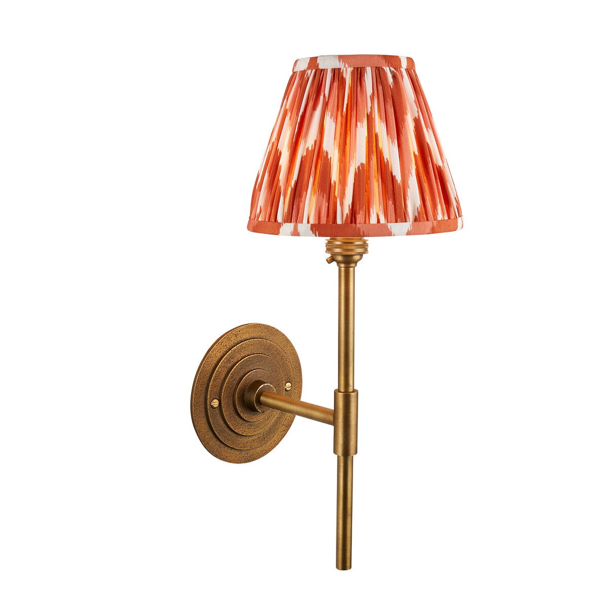 Halo antique brass wall light with a pleated orange zigzag ikat shade on a slim brass stem