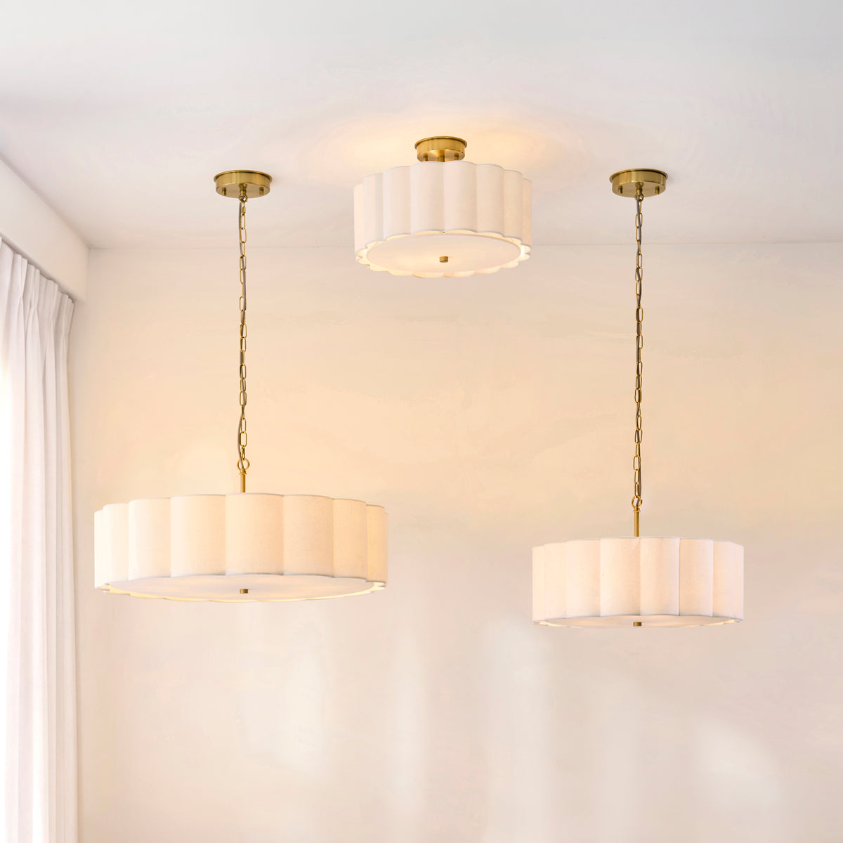 Serene pendant shown with two matching fittings in a pale room with white curtains