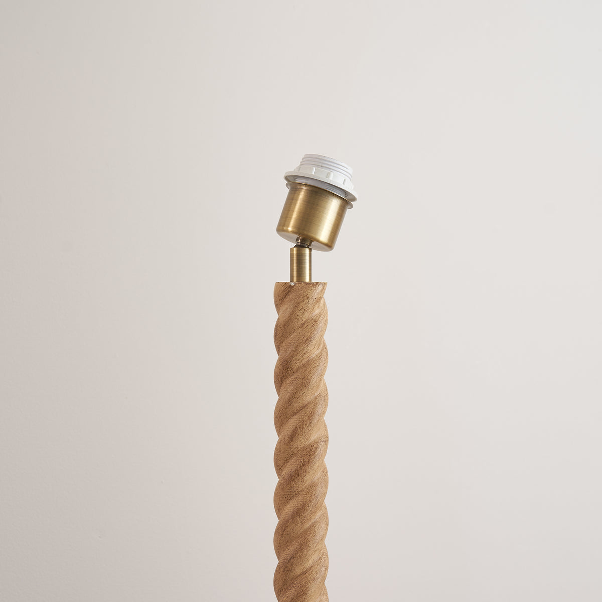 Brass bulb holder on the spiralled oak effect stem of the Twist floor lamp base