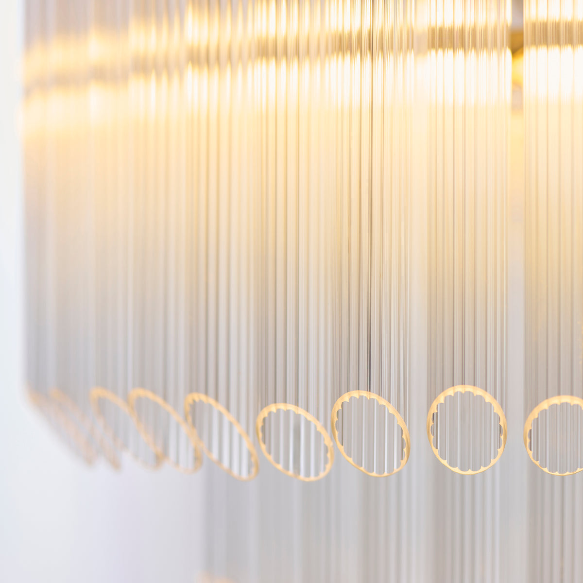 Detail of clear ribbed glass rods hung from brass loops on the Montpellier chandelier