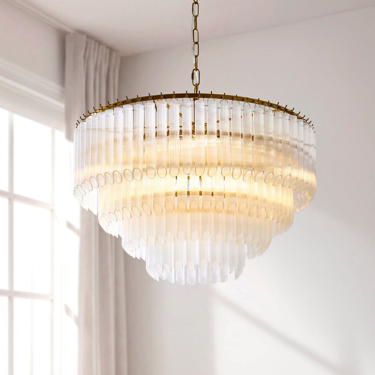 Montpellier chandelier glowing in a bright room with white curtains and a framed artwork