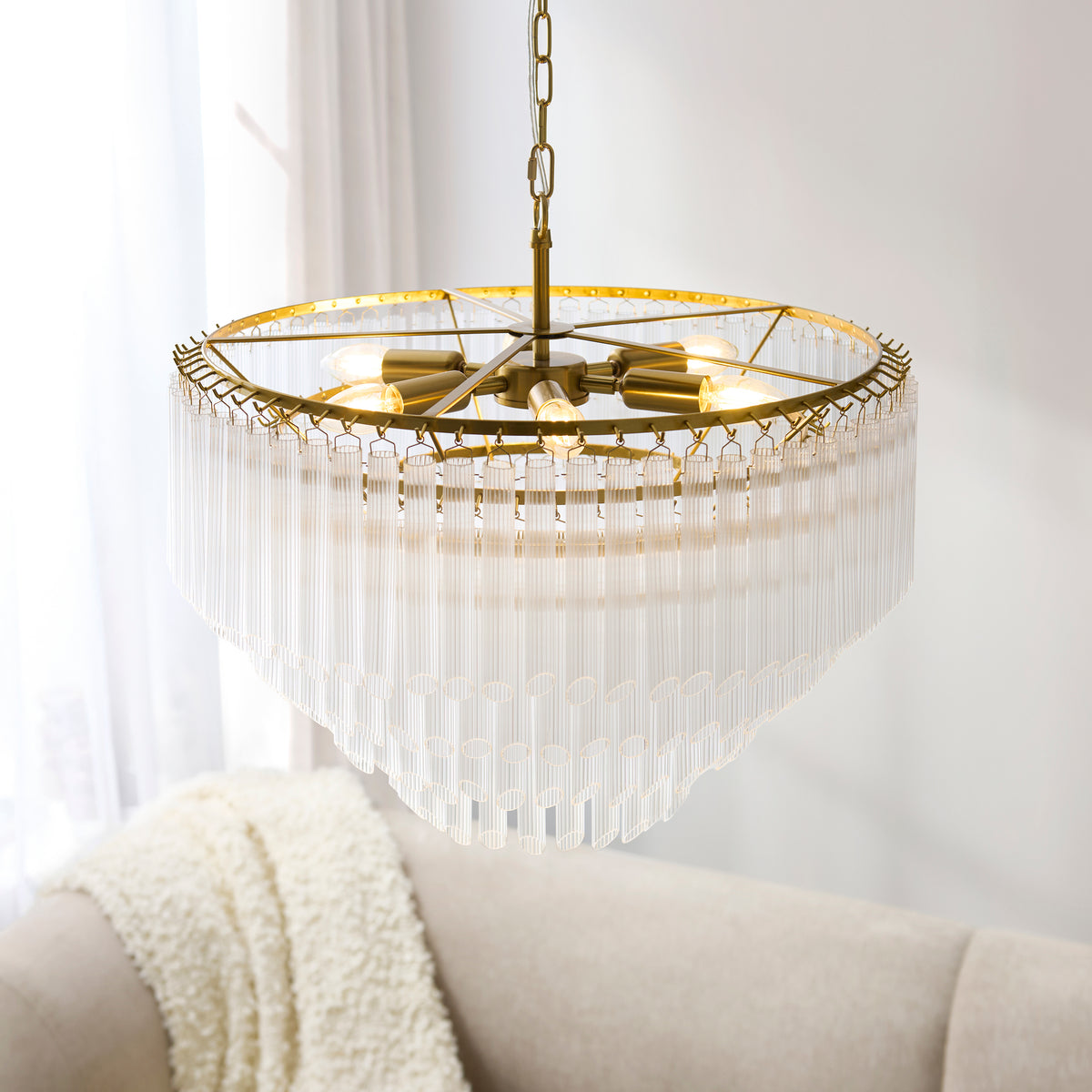 Wide Montpellier aged brass chandelier with tiered ribbed glass rods by a sunlit window