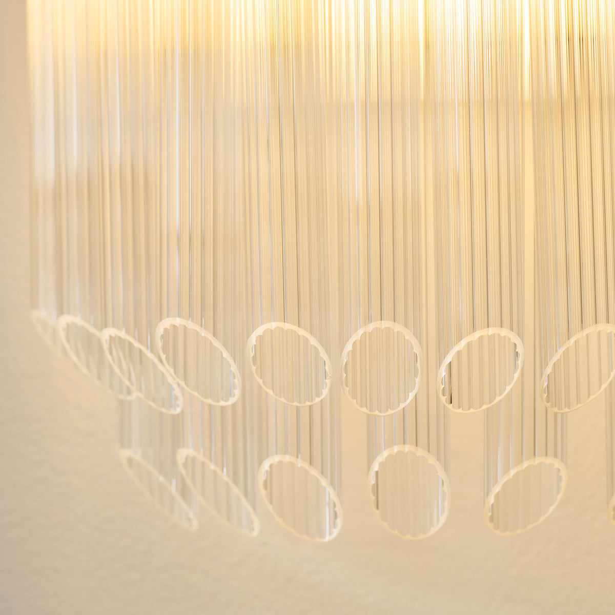 Detail of the tiered ribbed glass rod fringe on the lit Montpellier wall light