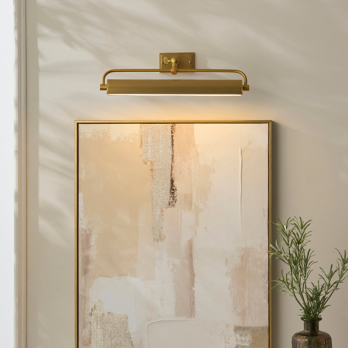 Nantes warm brass picture light lighting a framed abstract canvas on a pale wall