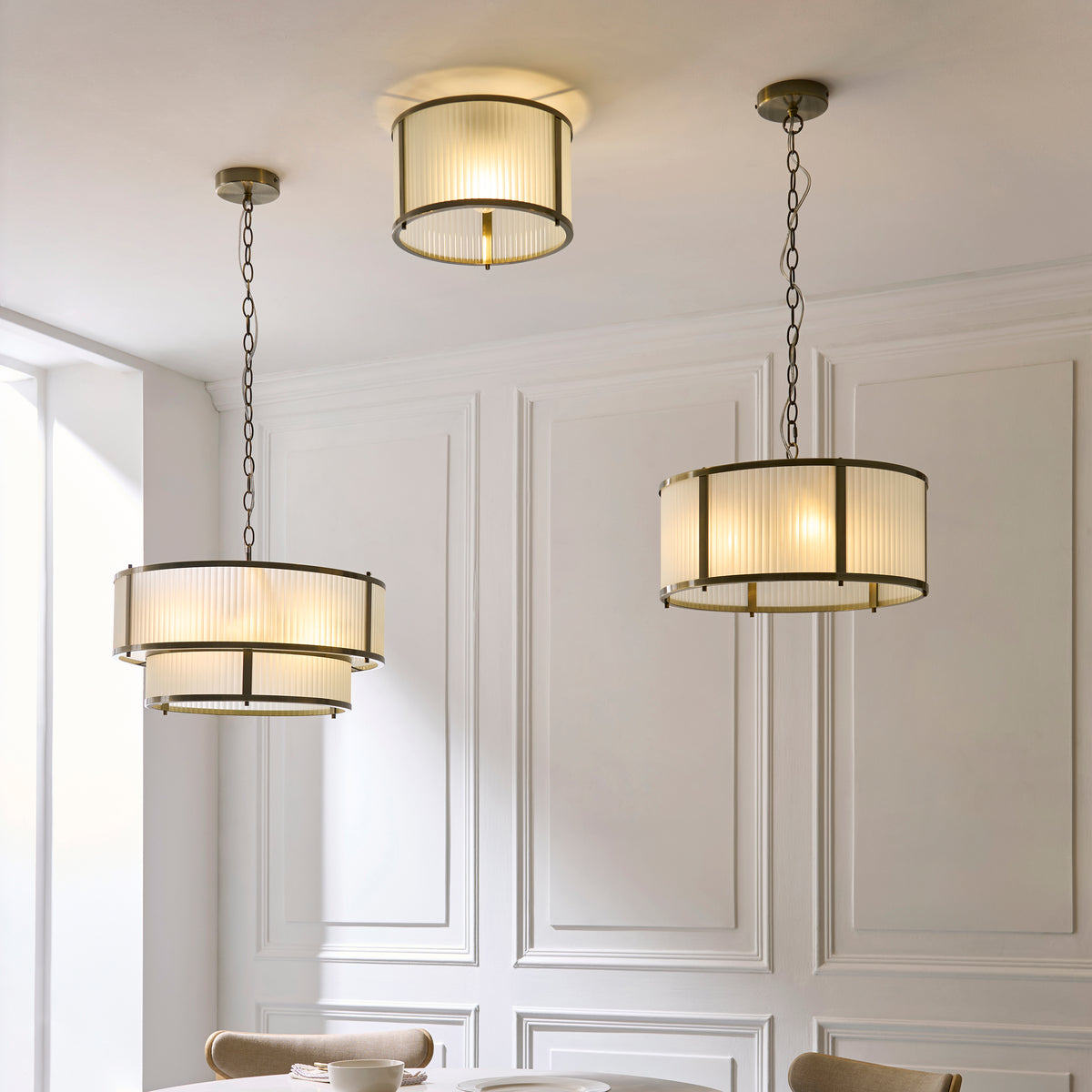 Three Ridgeton ribbed glass fittings, two pendants and a flush light, above a dining table