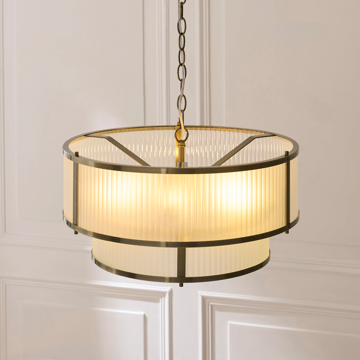 Angled view of the illuminated Ridgeton pendant showing its ribbed shades and brass frame rings