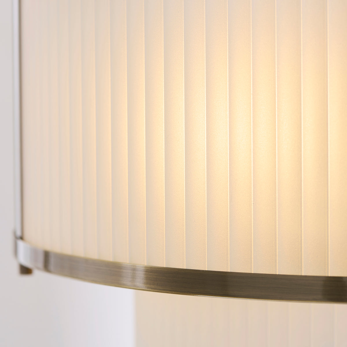 Detail of the ribbed ivory shade and brushed antique brass trim on the Ridgeton pendant