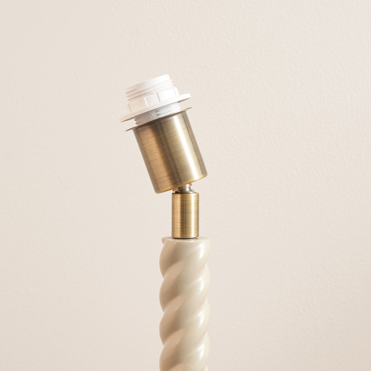 Brass bulb holder of the Twist almond white table lamp base, viewed from the side