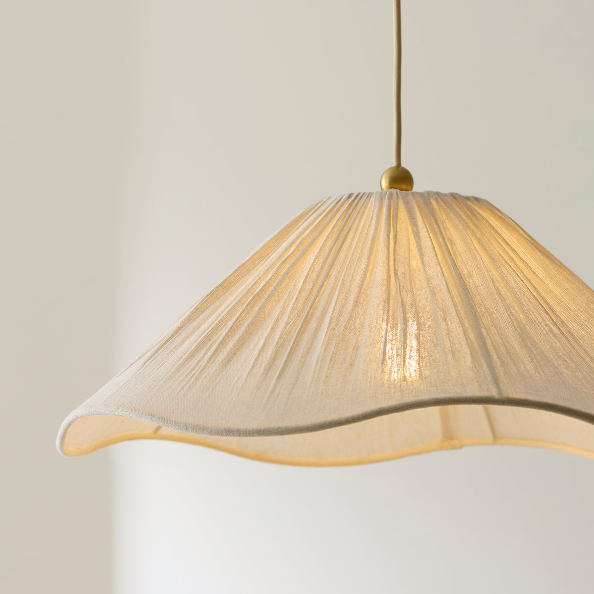 Close-up of the Isabella pendant's pleated fabric shade with softly waved edge