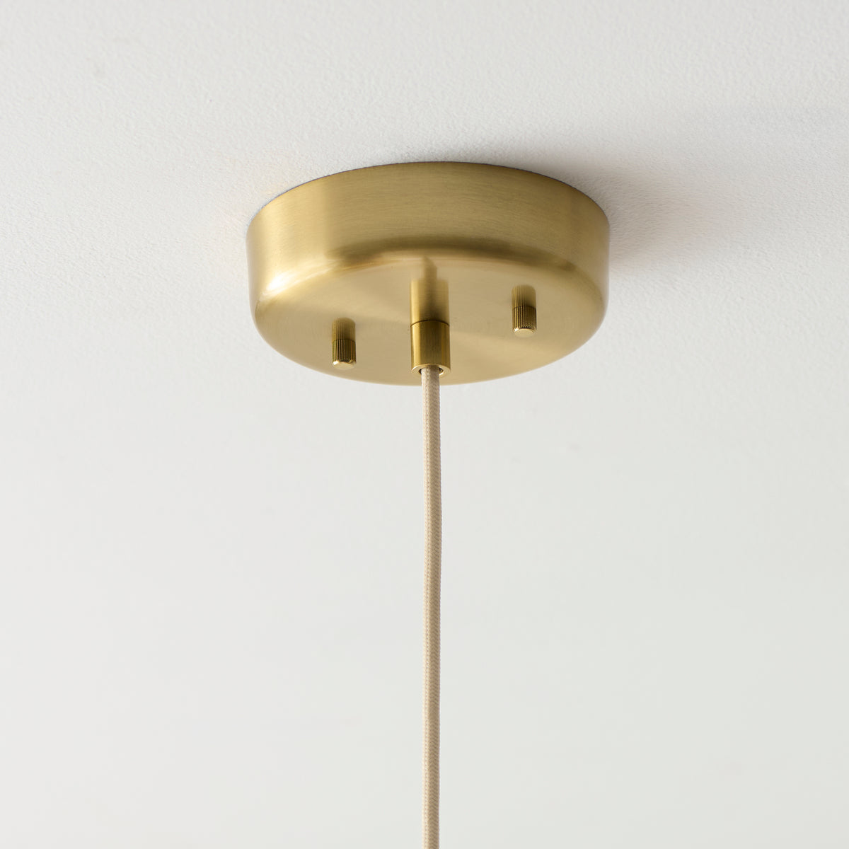 Brushed brass ceiling rose and fabric flex of the Isabella pendant light