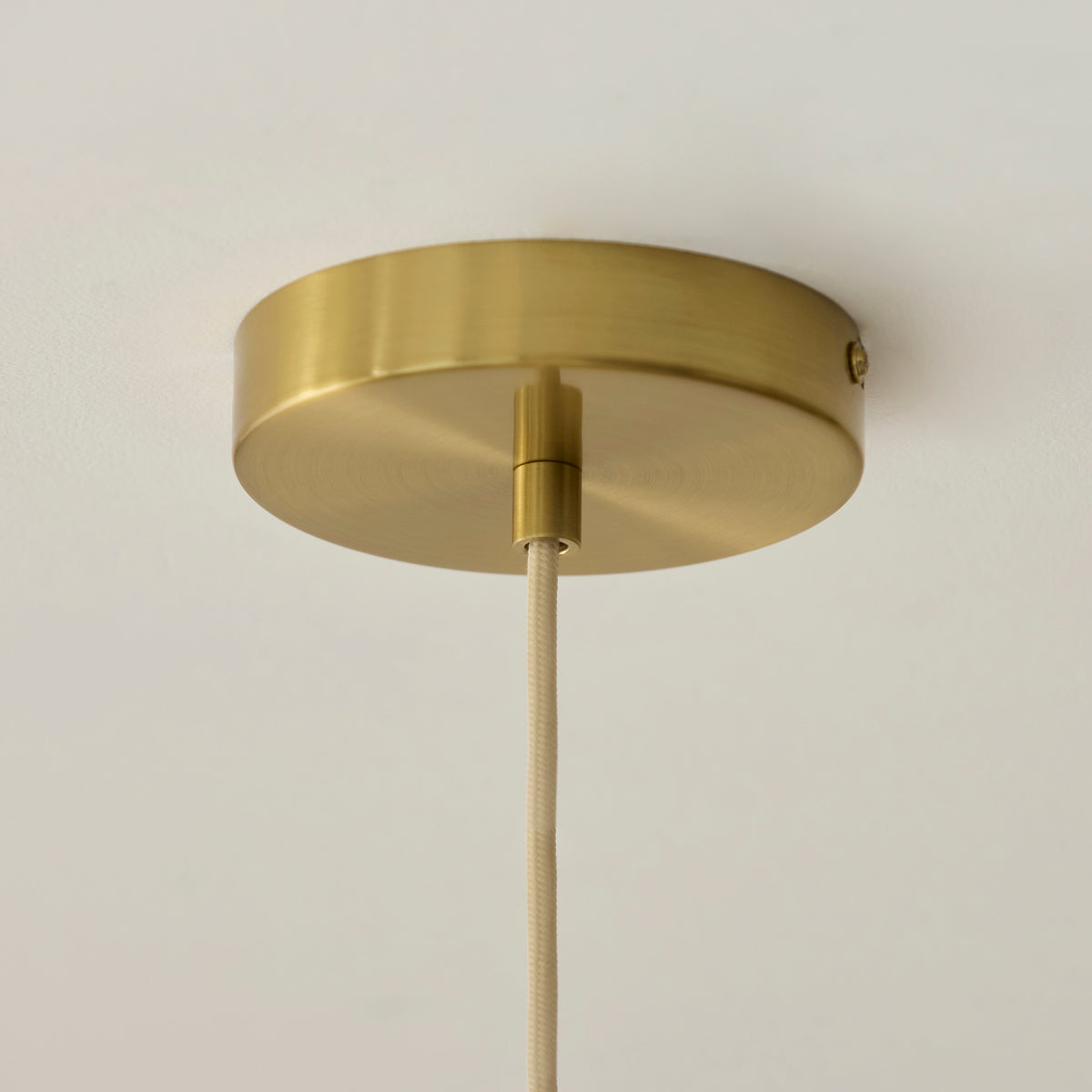 Brushed brass ceiling rose and braided flex of the Noah pendant light