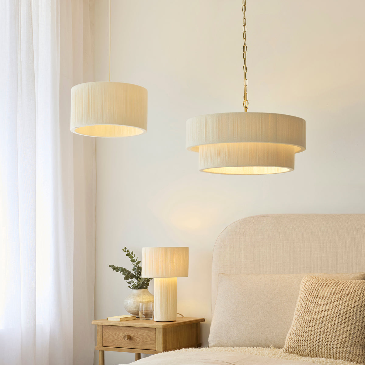 Noah cream pendants and a matching table lamp lit in a softly furnished bedroom