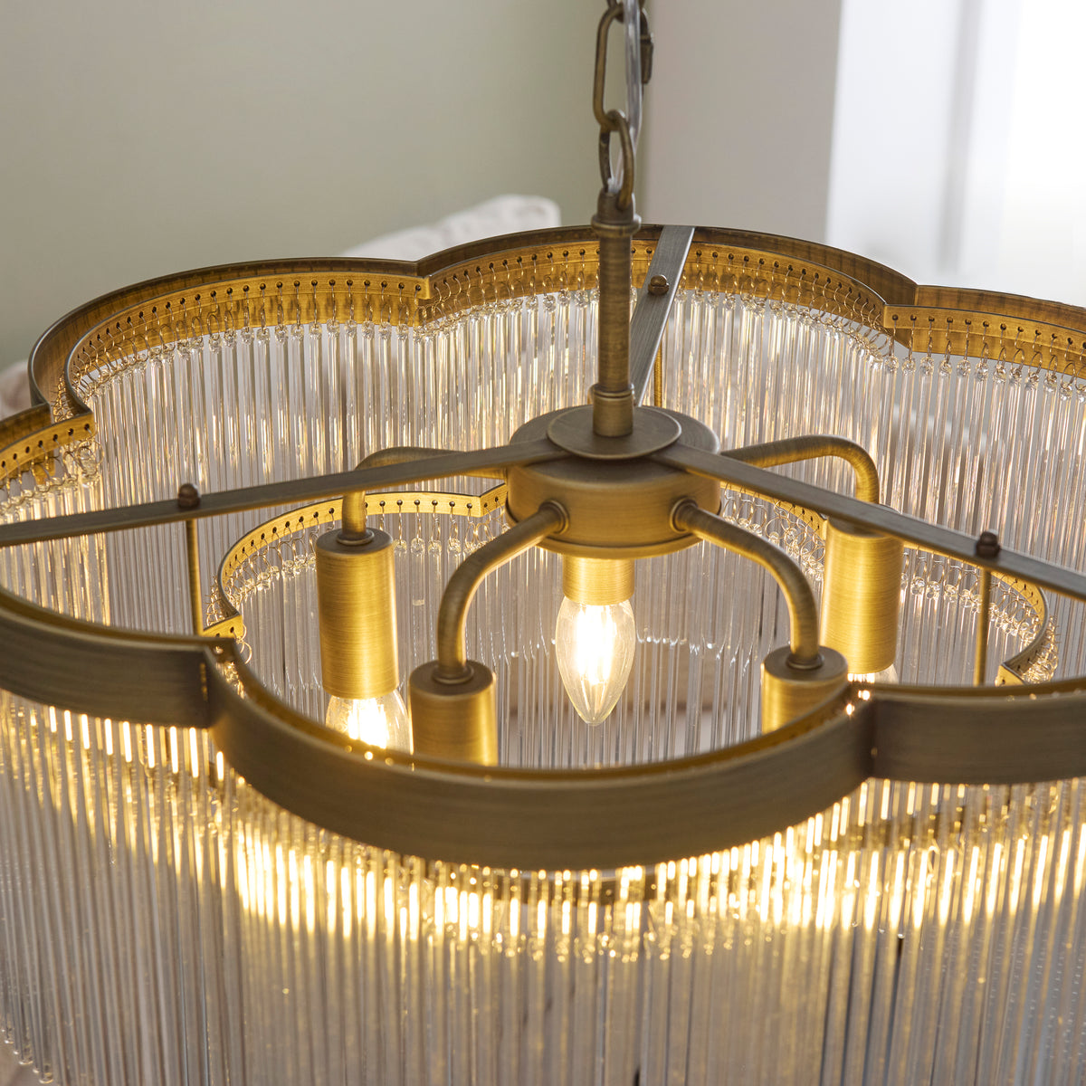Lucille chandelier interior showing brass arms, five lamp holders and a lit filament bulb