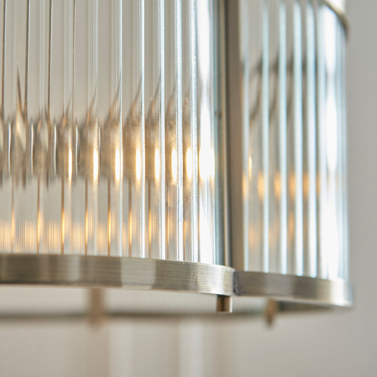 Close-up of the ribbed glass panel and brushed antique brass rim on the Ridgeton Scallop pendant