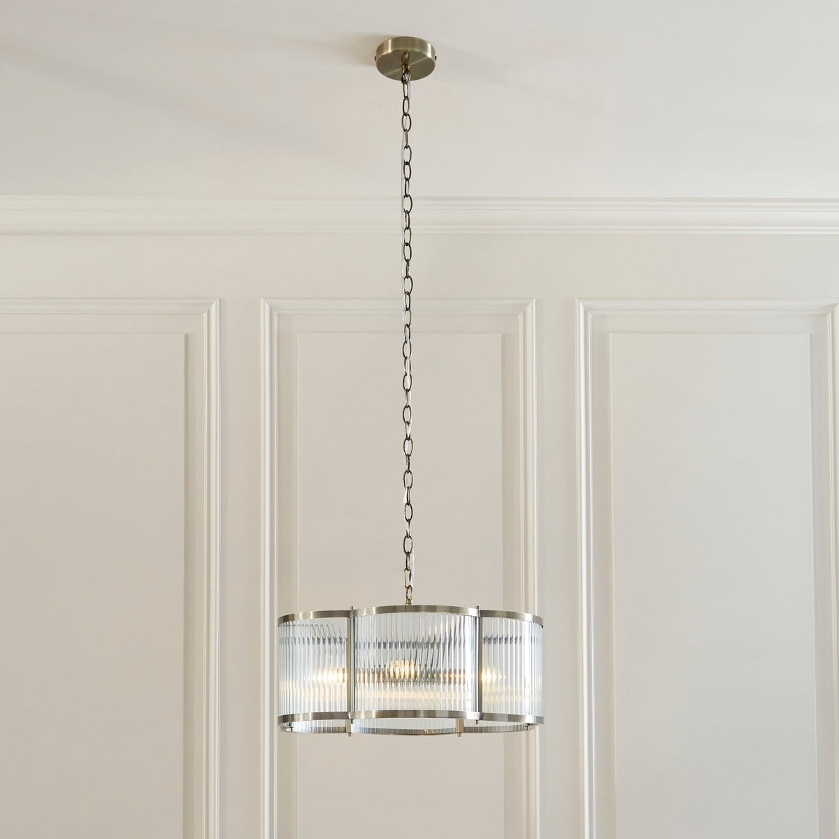 Ridgeton Scallop chandelier hanging from a chain against a panelled cream dining room wall