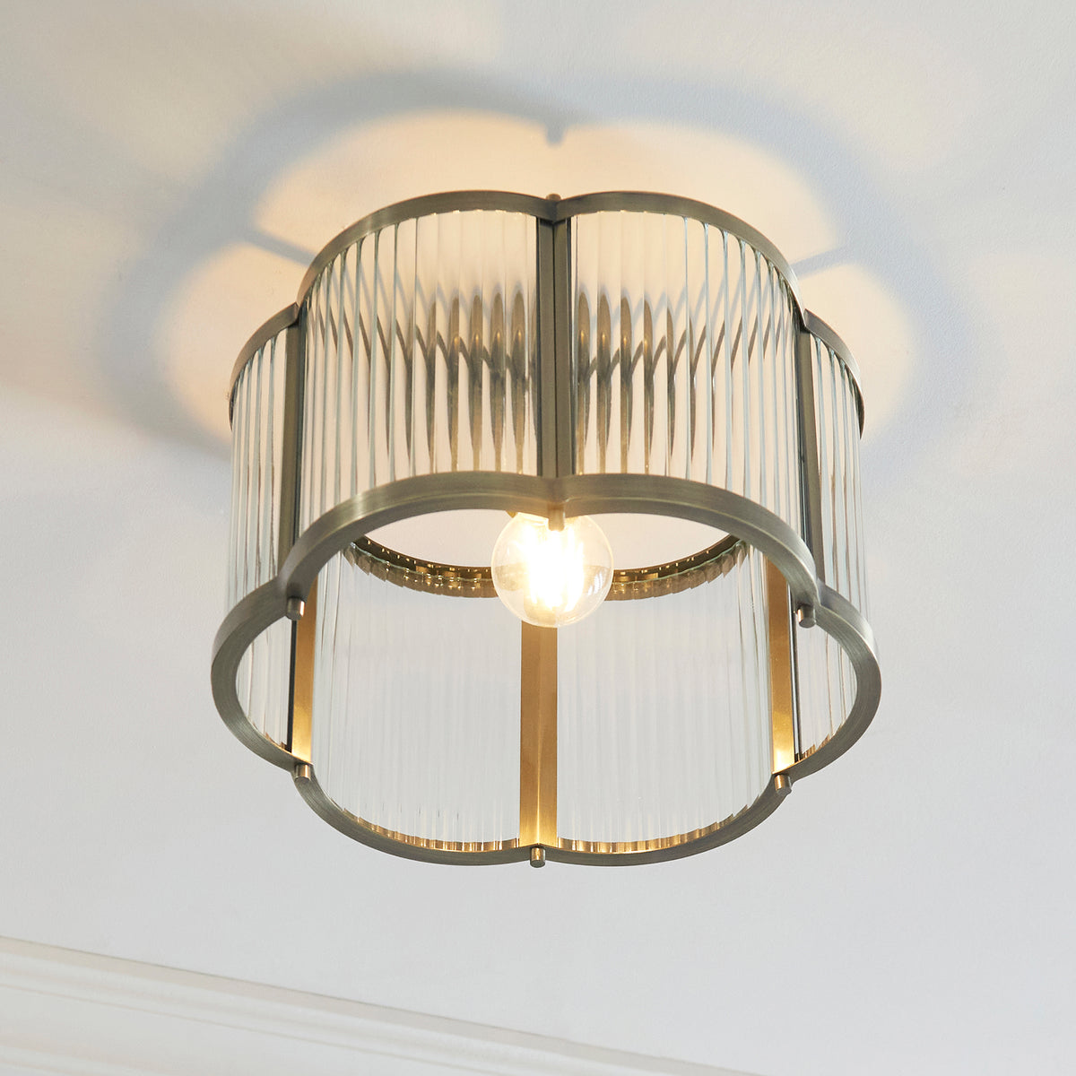 Ridgeton Scallop ceiling light from directly below, showing the bulb within the scalloped brass frame