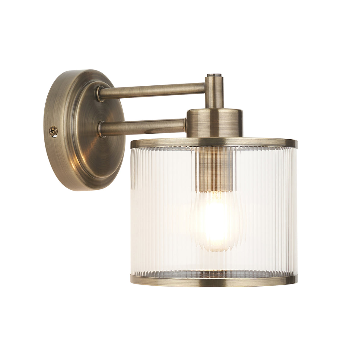Ridgeton antique brass wall light with a ribbed glass drum shade and exposed filament bulb
