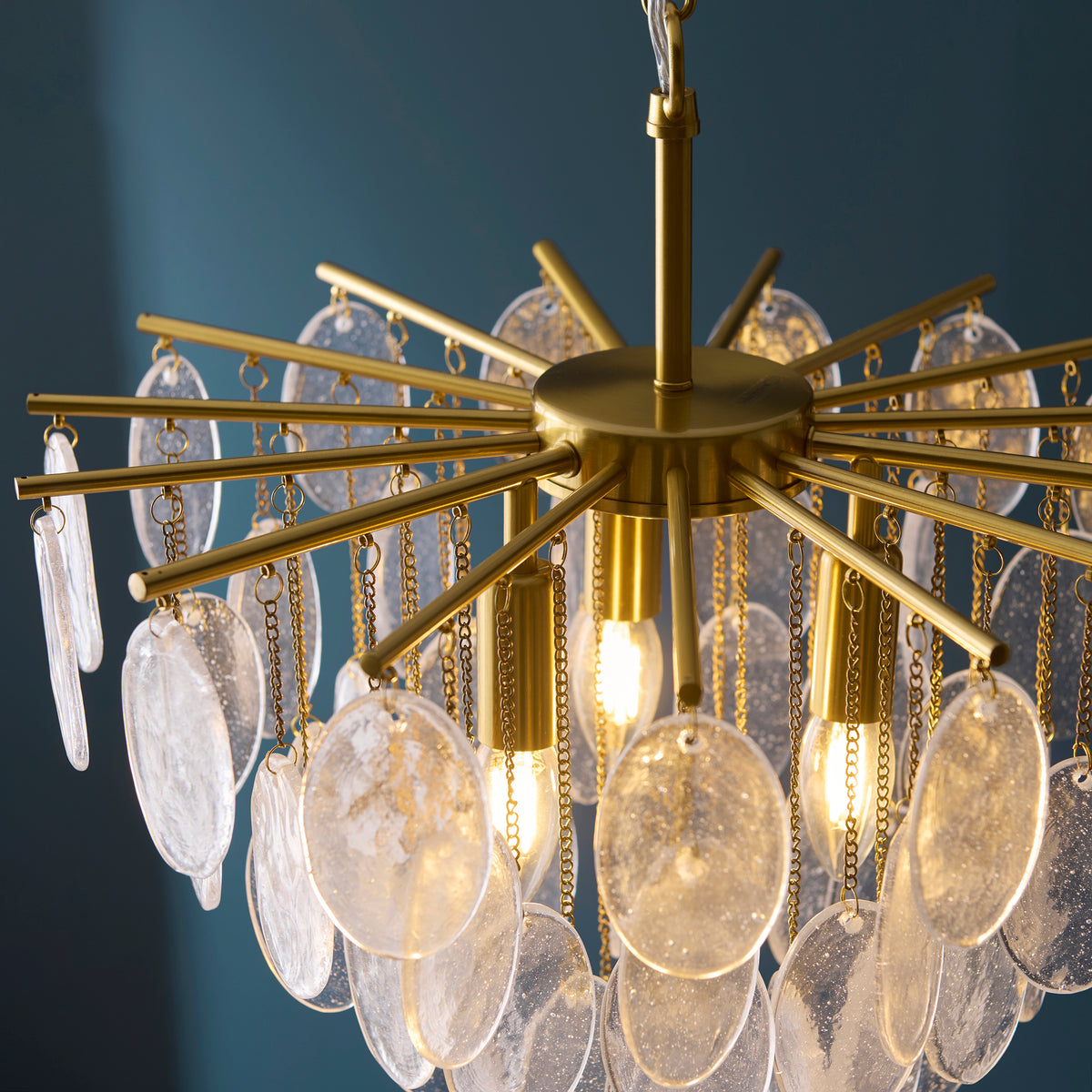 Loretta pendant from above, showing brass spokes and chains holding textured glass discs