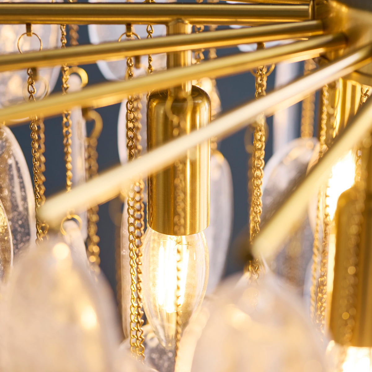 Close-up of the Loretta pendant's brass lamp holders and hanging bubble glass plates