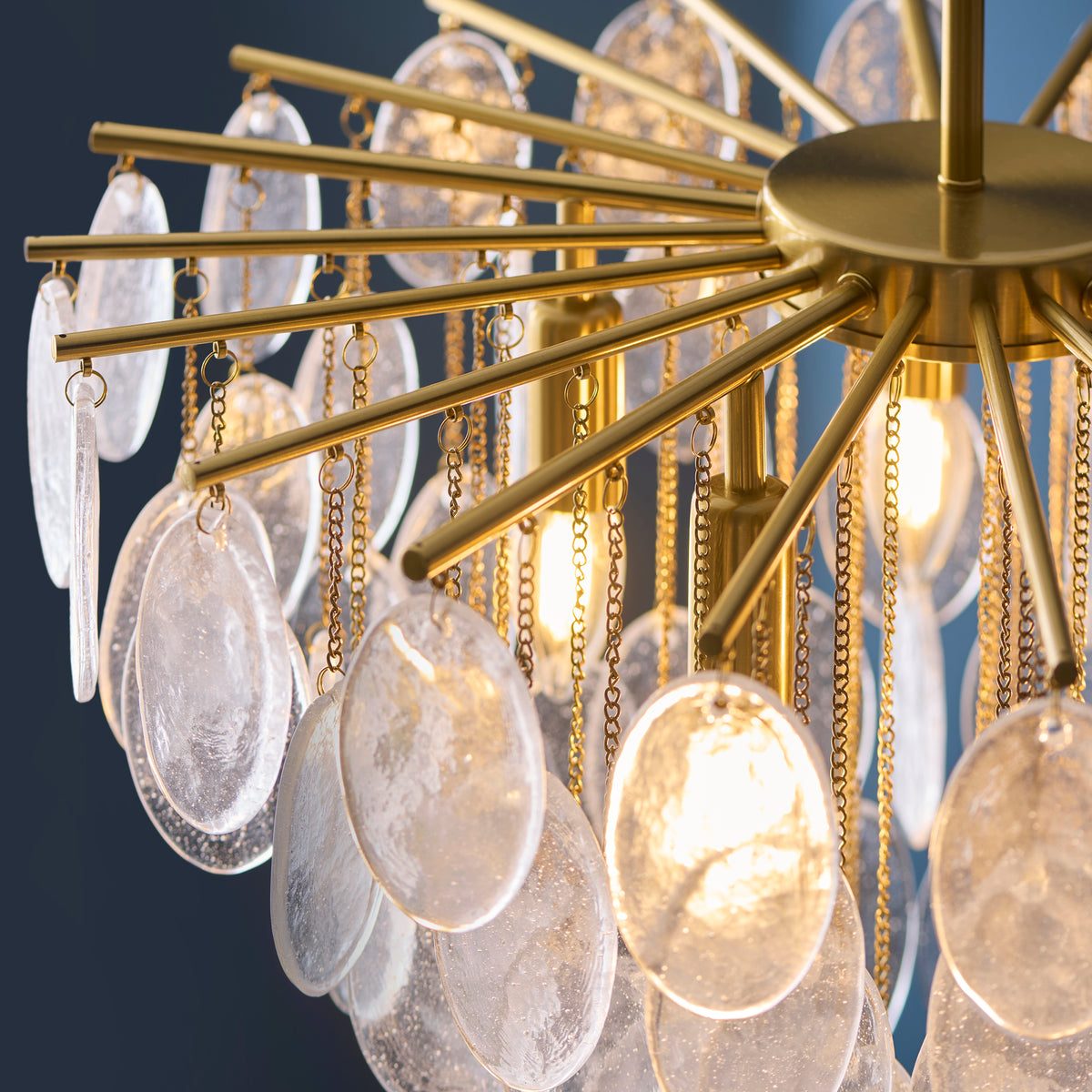 Underside view of the Loretta chandelier showing brass arms, chains and illuminated glass discs
