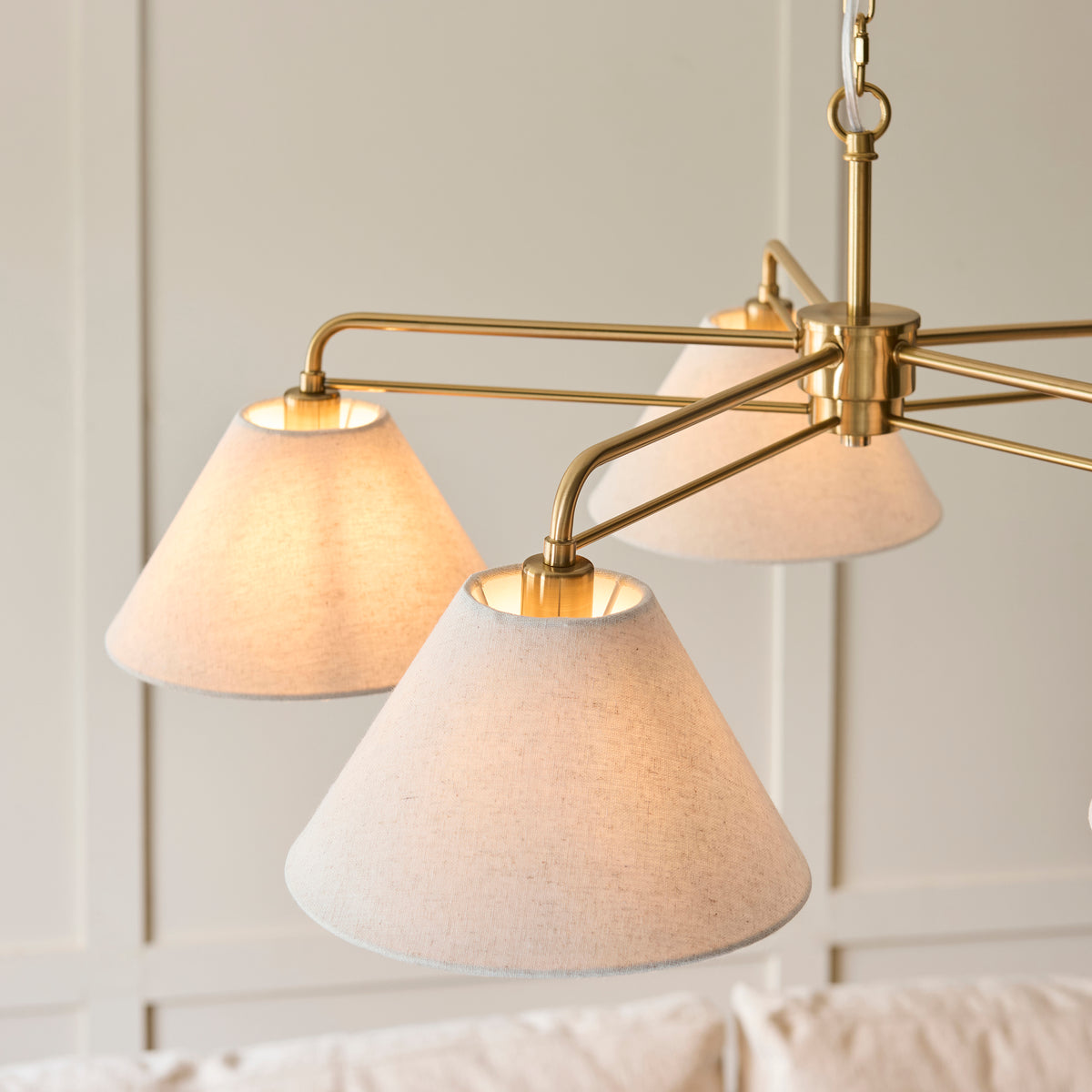 Detail of three linen shades and aged brass arms on the Wallbridge pendant light