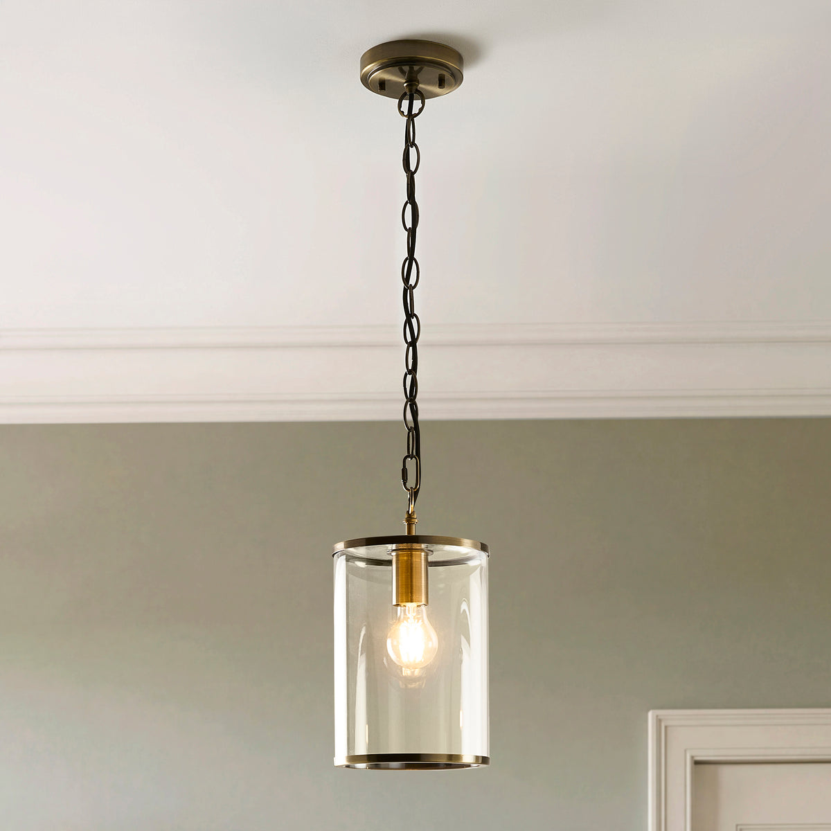 Close-up of the Hebden pendant's lit filament bulb inside its clear glass cylinder shade