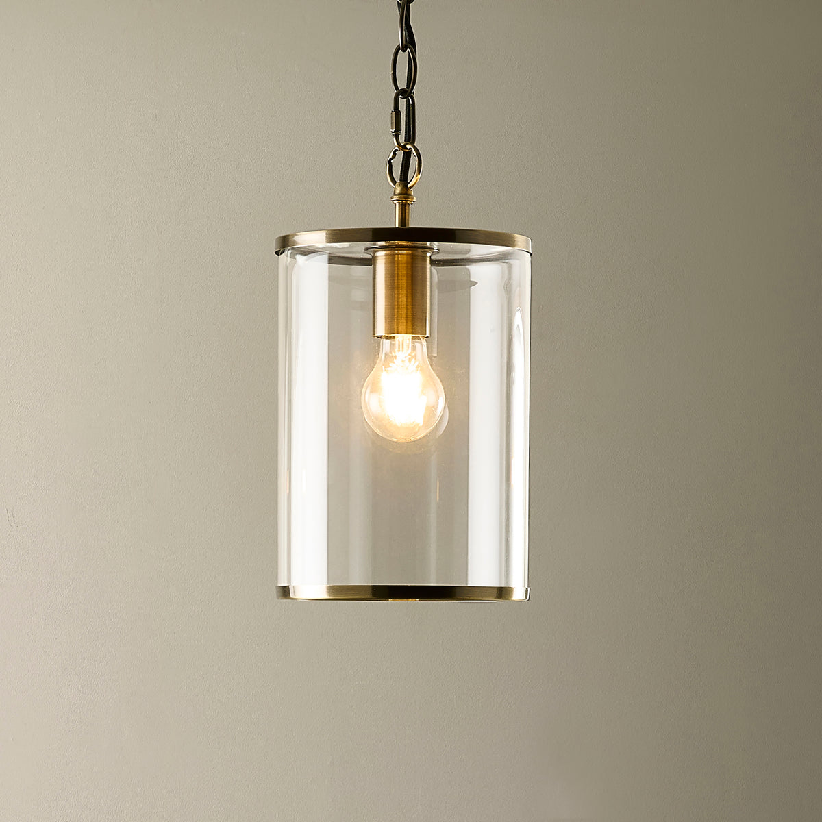 Detail of the brushed antique brass rim at the base of the Hebden pendant's glass shade