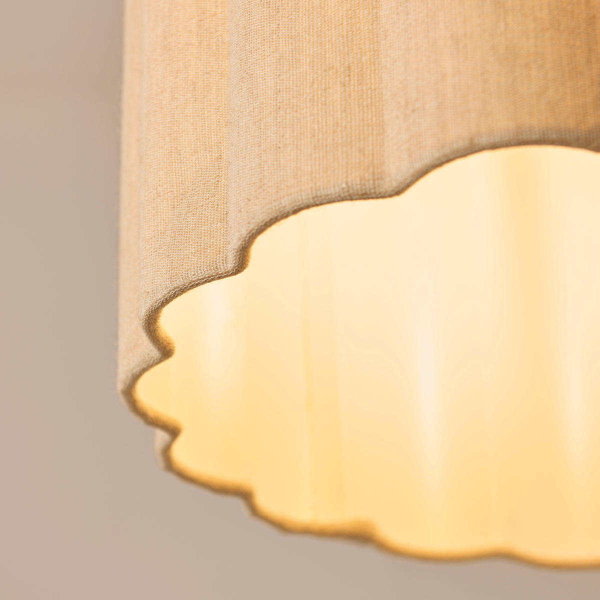 Underside of the Olson pendant showing the scalloped diffuser glowing inside the shade