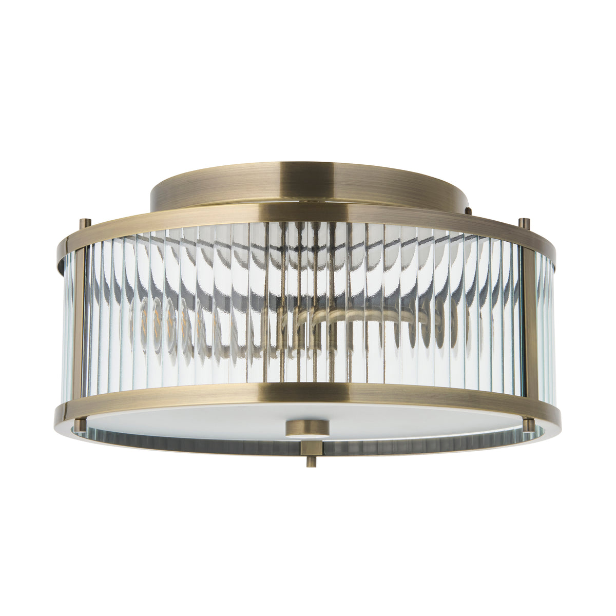 Ridgeton antique brass bathroom flush light with ribbed glass drum on a plain background