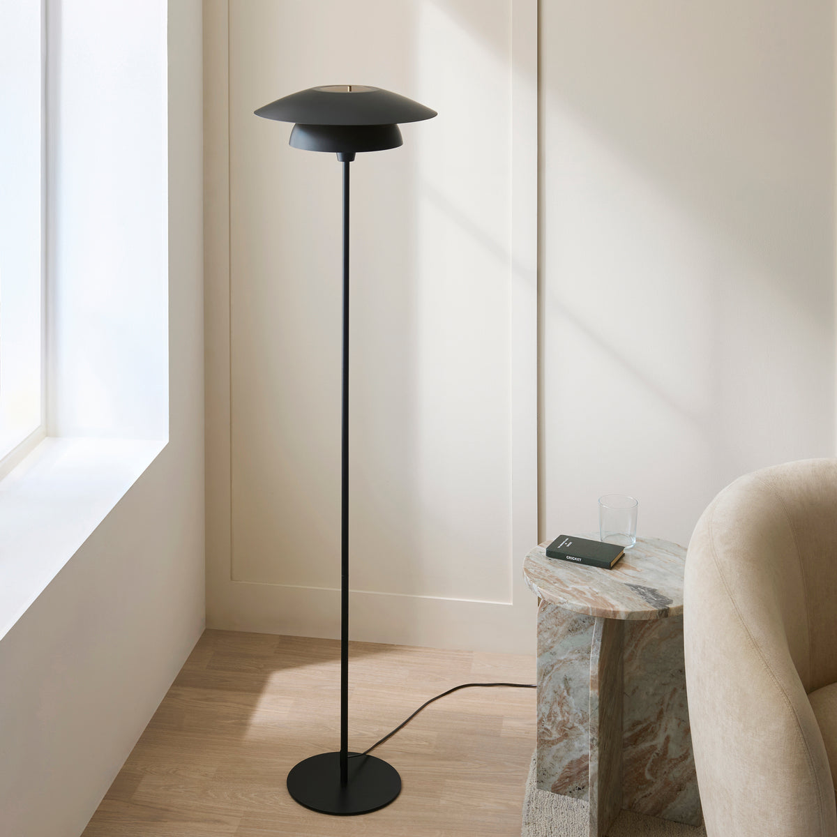 Lyon black and brass floor lamp in a panelled living room corner with oak flooring