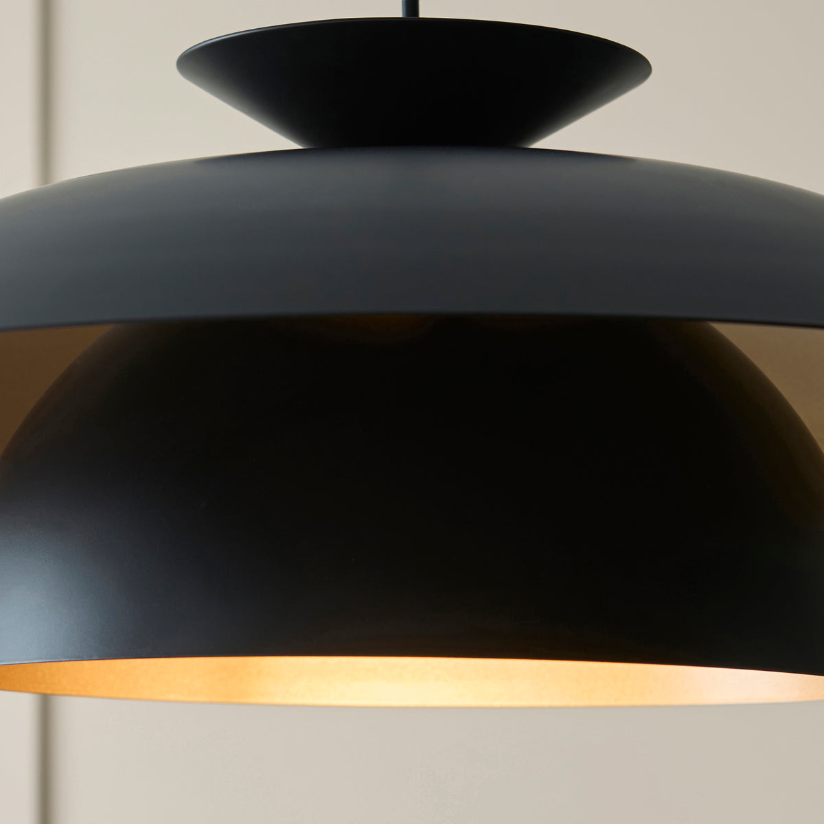 Close-up of the Lyon pendant underside showing the warm brass-lined inner dome