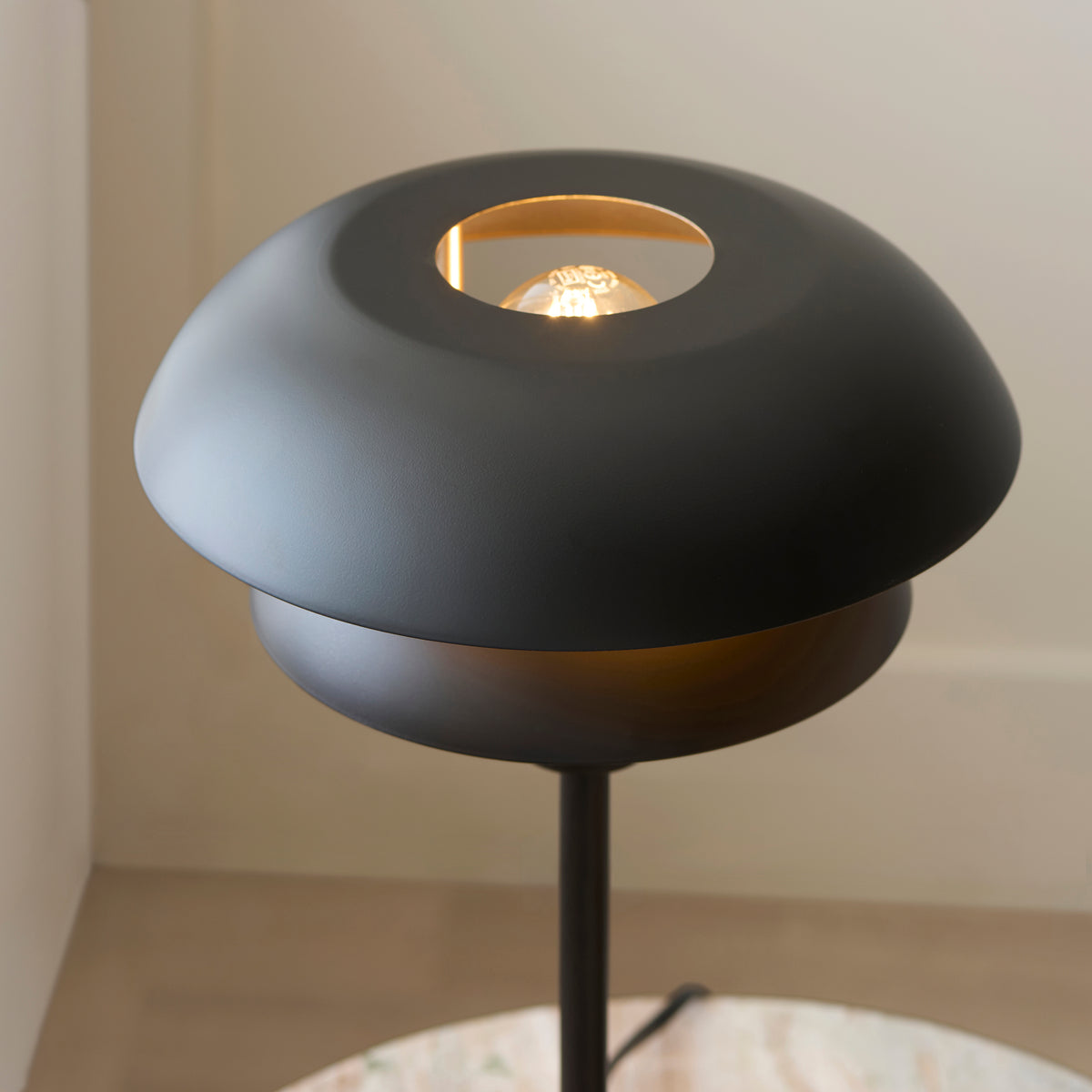 Detail of the Lyon table lamp shade aperture showing the filament lamp inside