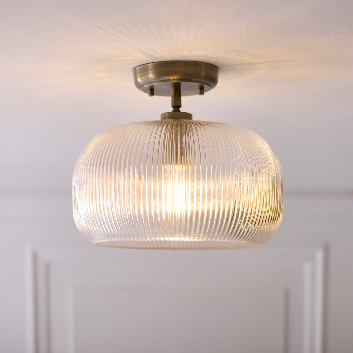 Harborne antique brass flush light casting patterned light across the ceiling