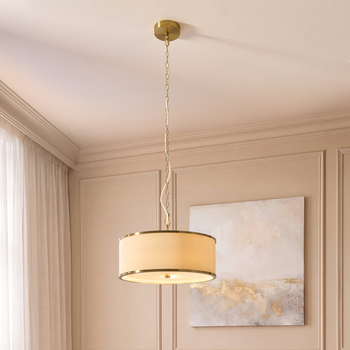 Lexi pendant light hanging in a beige bedroom beside a gold-flecked canvas and sheer curtains