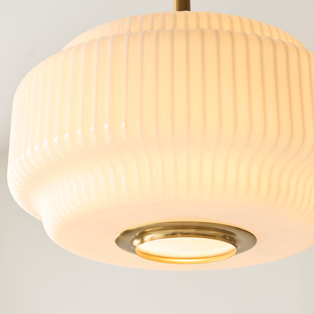 Underside detail of the Evora pendant's brass ring and glowing opal glass diffuser