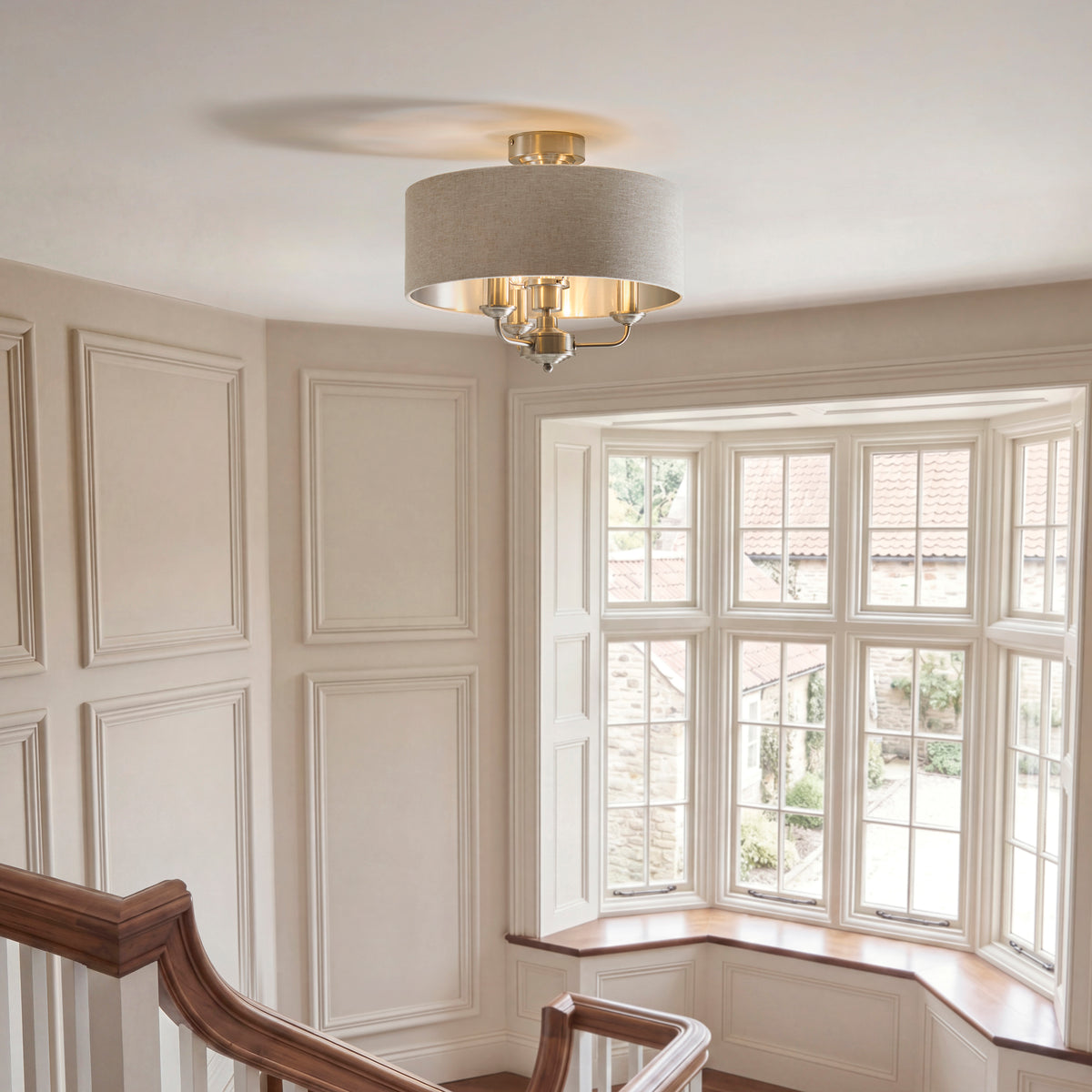 Highclere flush ceiling light lit above a panelled stairwell landing with a bay window