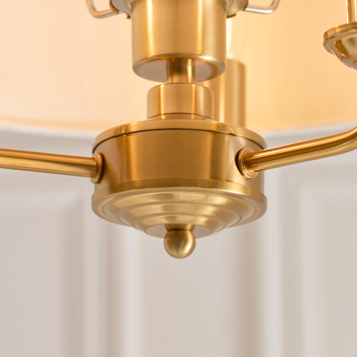 Close-up of the Highclere light's vintage brass central boss and curved arms