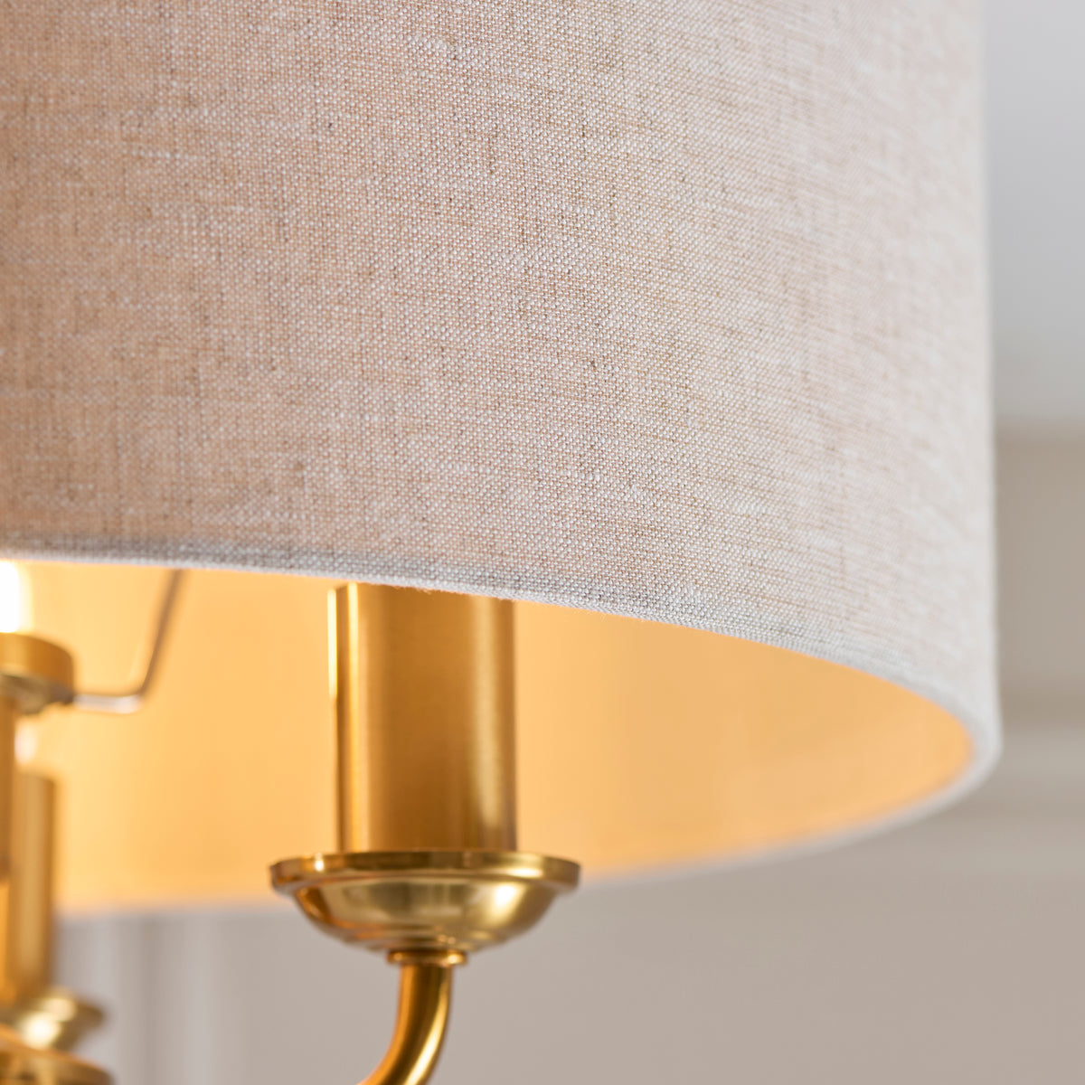 Detail of the Highclere linen shade rim with warm brass lamp holders inside