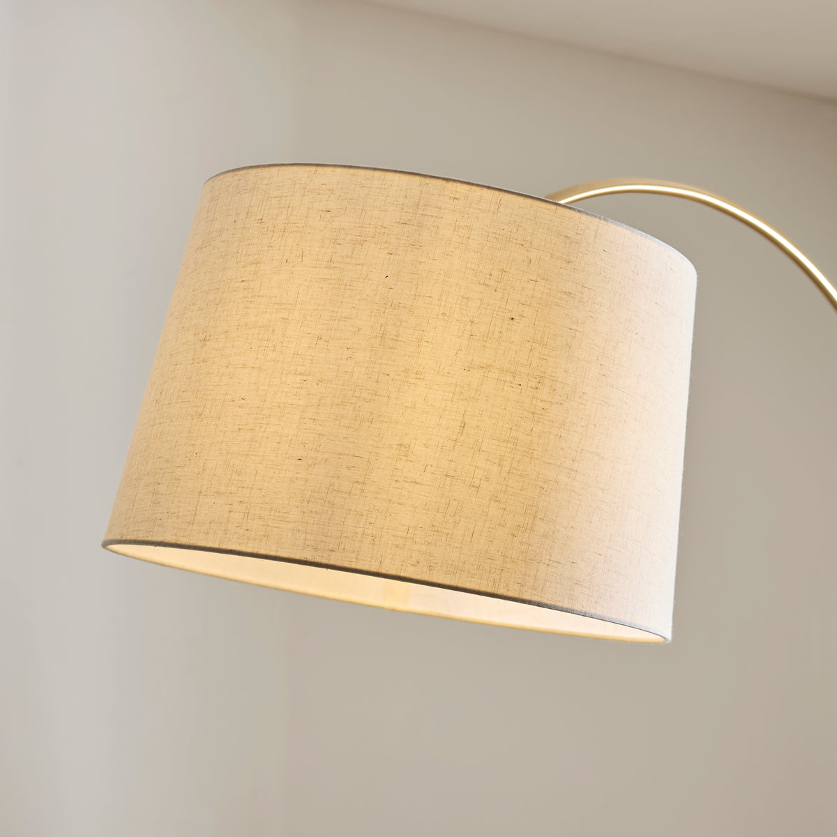 Close-up of the Carlson XL floor lamp's natural linen drum shade and brass arched arm