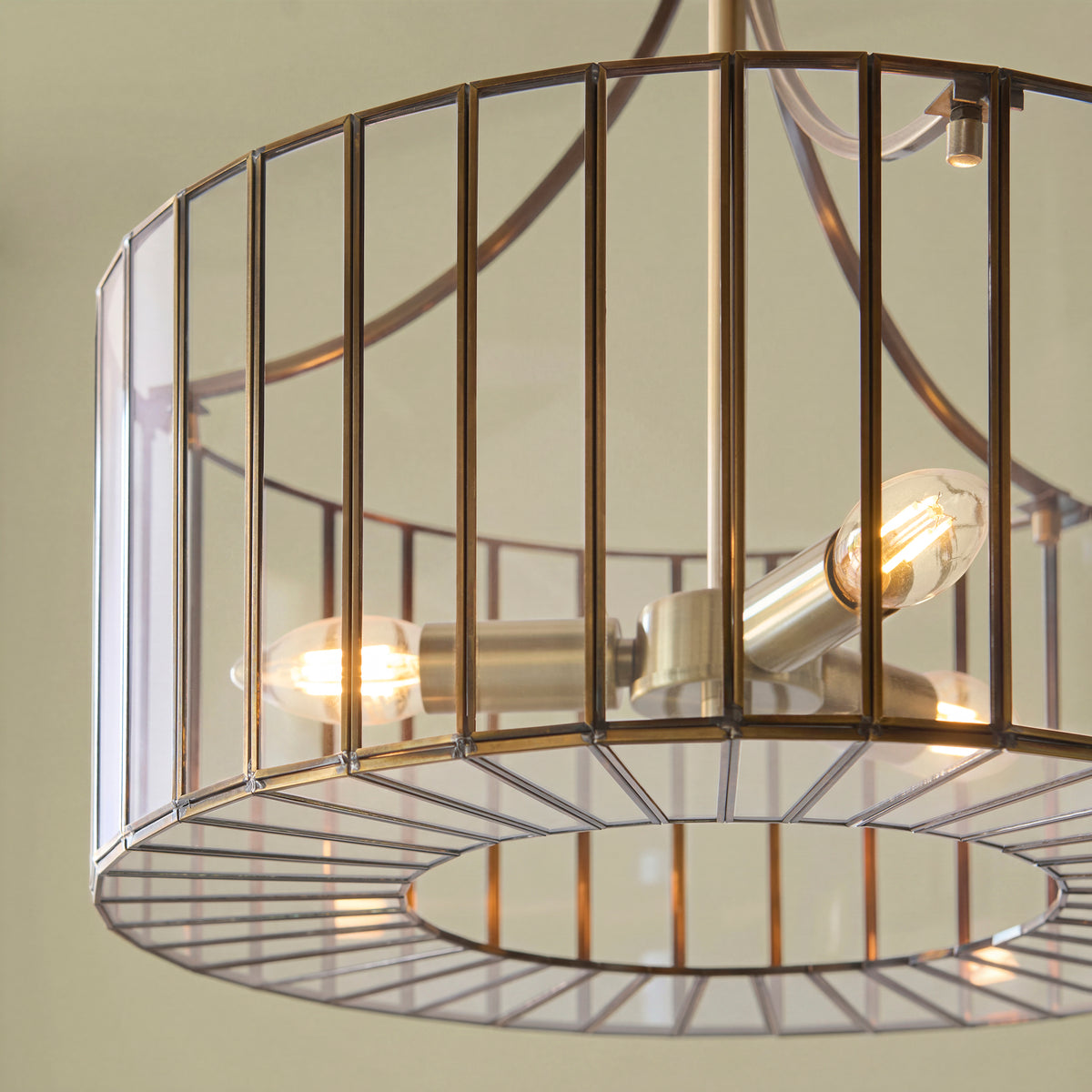 Close-up of the Antalya pendant's brass cage shade and glowing candle lamps