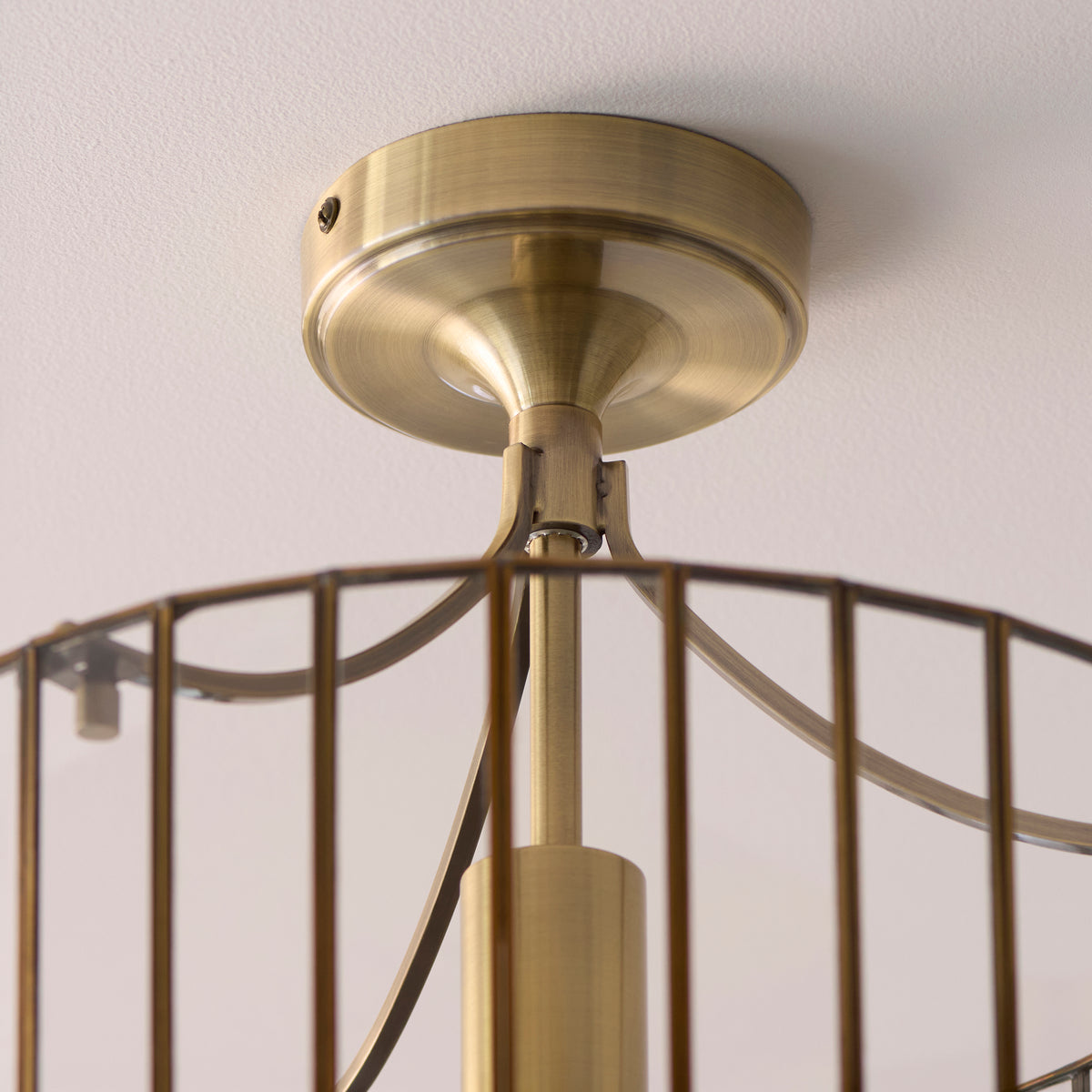 Close-up of the Antalya flush light's antique brass ceiling plate and stem