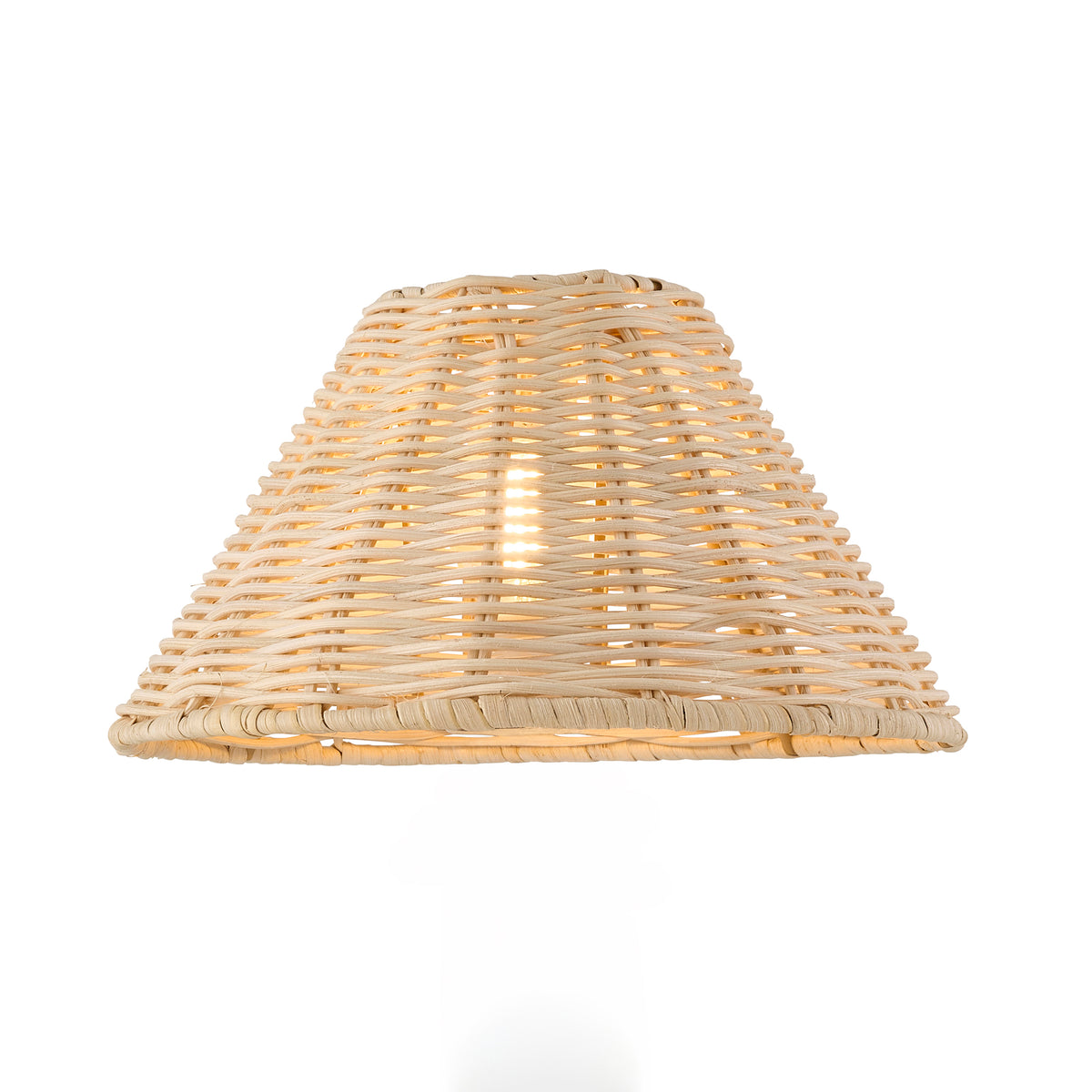 Tapered natural rattan lamp shade lit from within, showing the woven weave