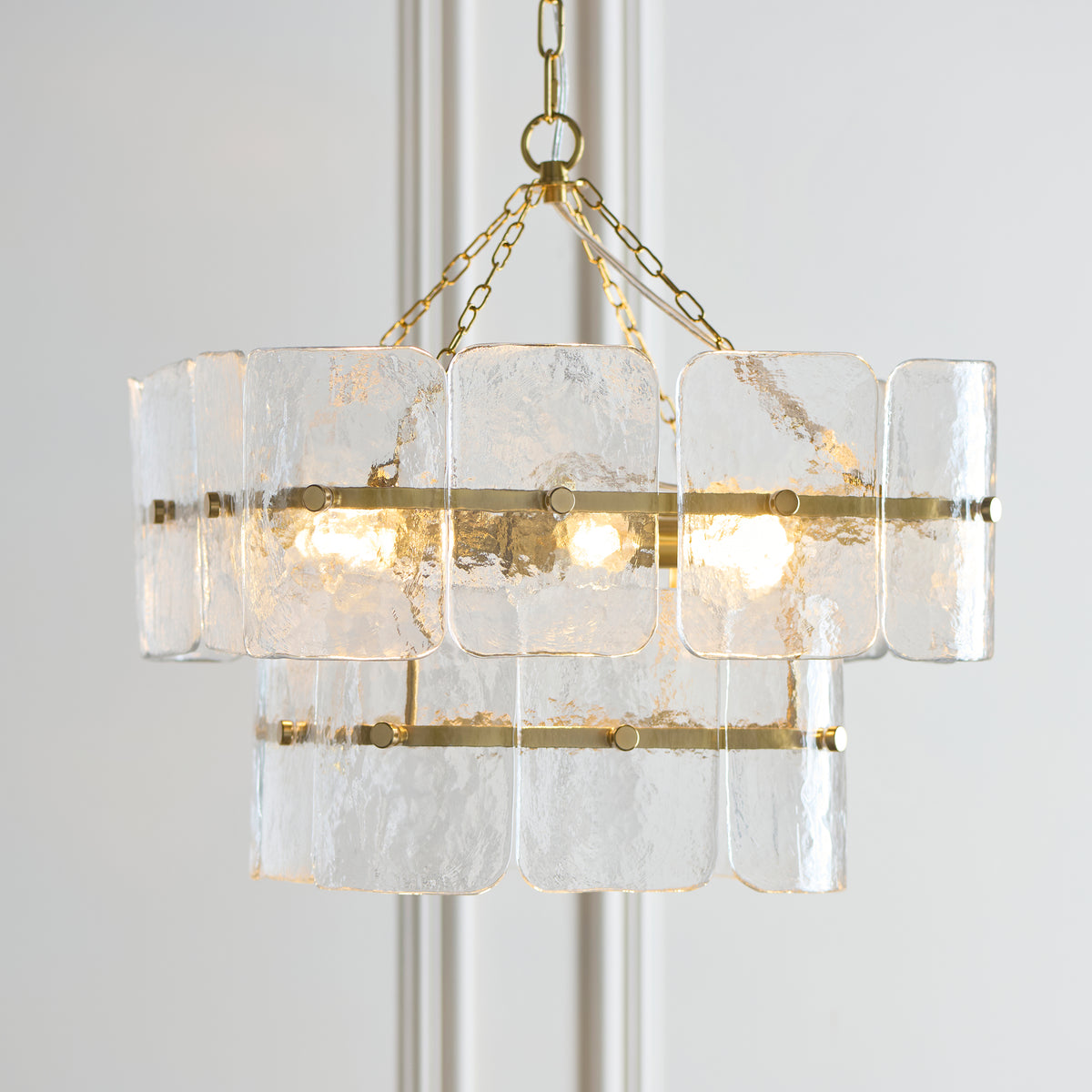 Close view of the Venice pendant's rippled glass tiles and aged brass banding