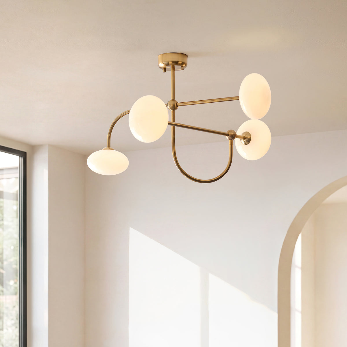 Ottowa semi flush ceiling light lit in a bright white room beside a garden window