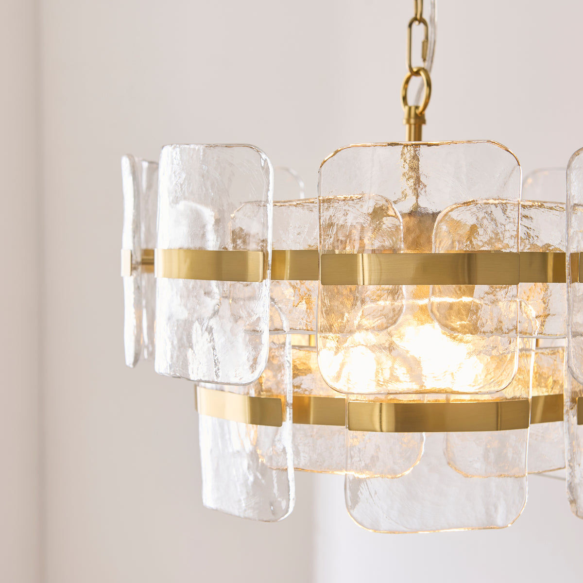 Close-up of the Ancara pendant's handmade textured glass panels and brushed brass bands
